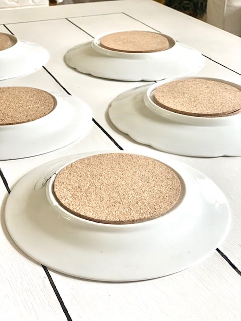 Plates with cork coasters glued. These cork coasters help to fill in the rim of the bottom of the plates so they adhere better. 