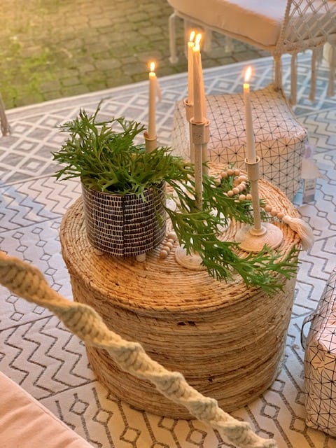 wicker ottoman as a coffee table. pictured here with candle sticks and plants. 