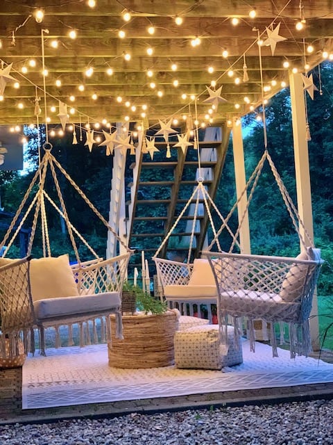 night view of the outdoor seating area with 4 hammock swings hanging from the ceiling joists. 