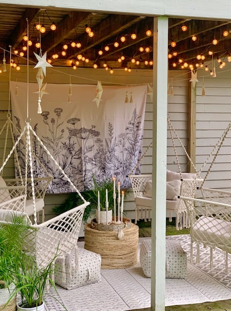 Wildflower outdoor tapestry hanging on the side of the house as a back drop for this space. 