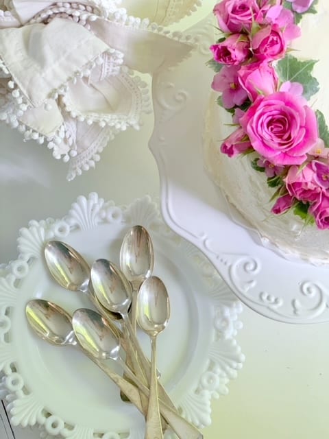cake with fresh flowers with spoons and dishes