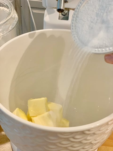 pouring sugar in mixing bowl with butter