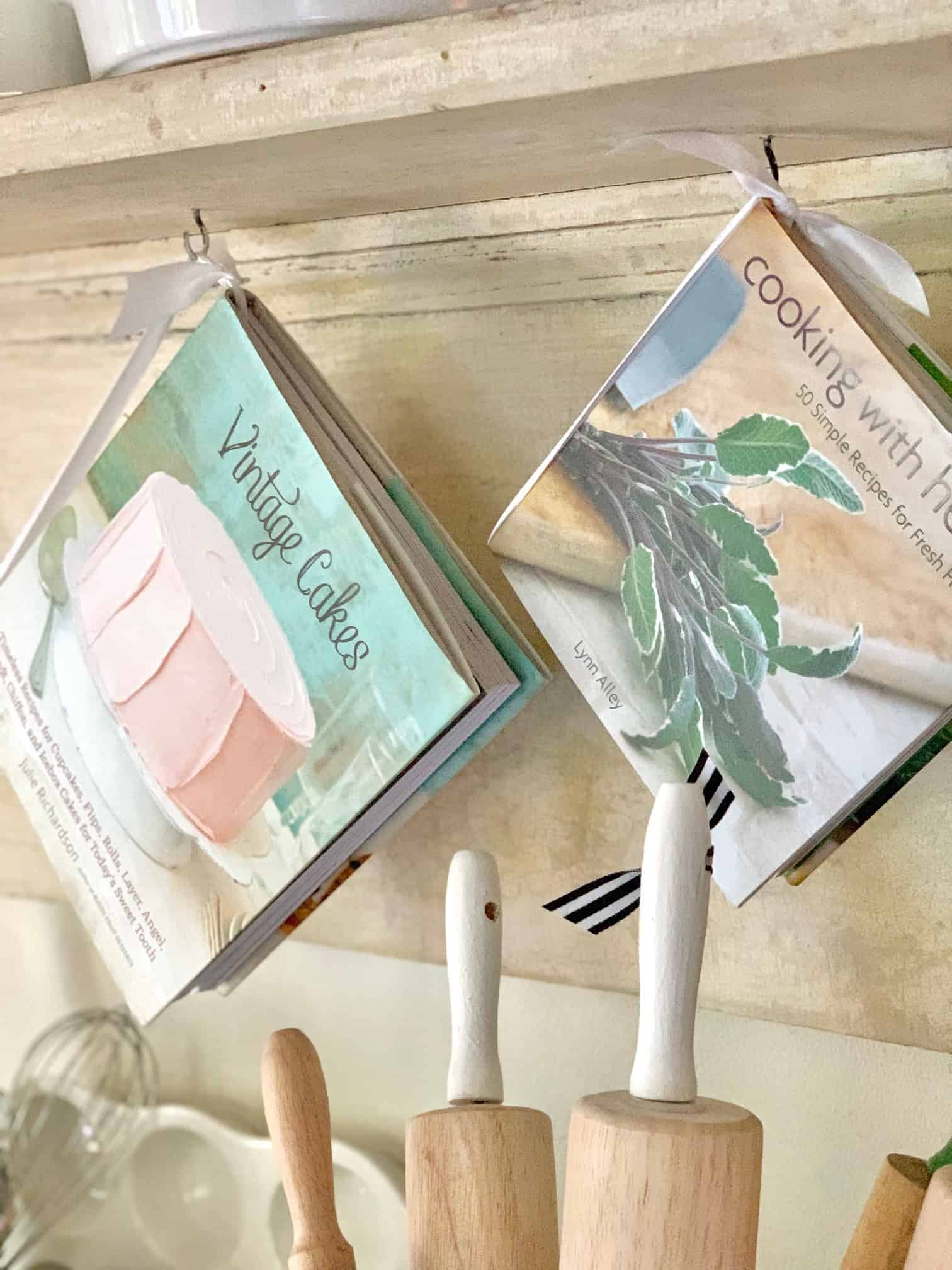 Cookbooks hanging from the shelf with ribbon. 