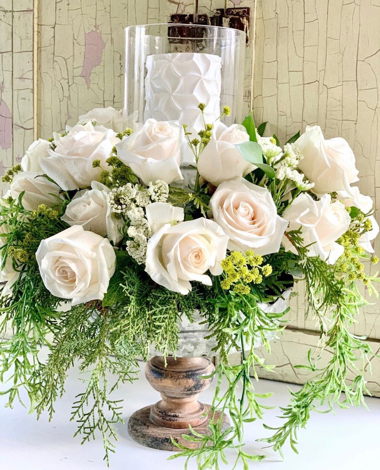 A pretty white rose arrangement on a pedestal.