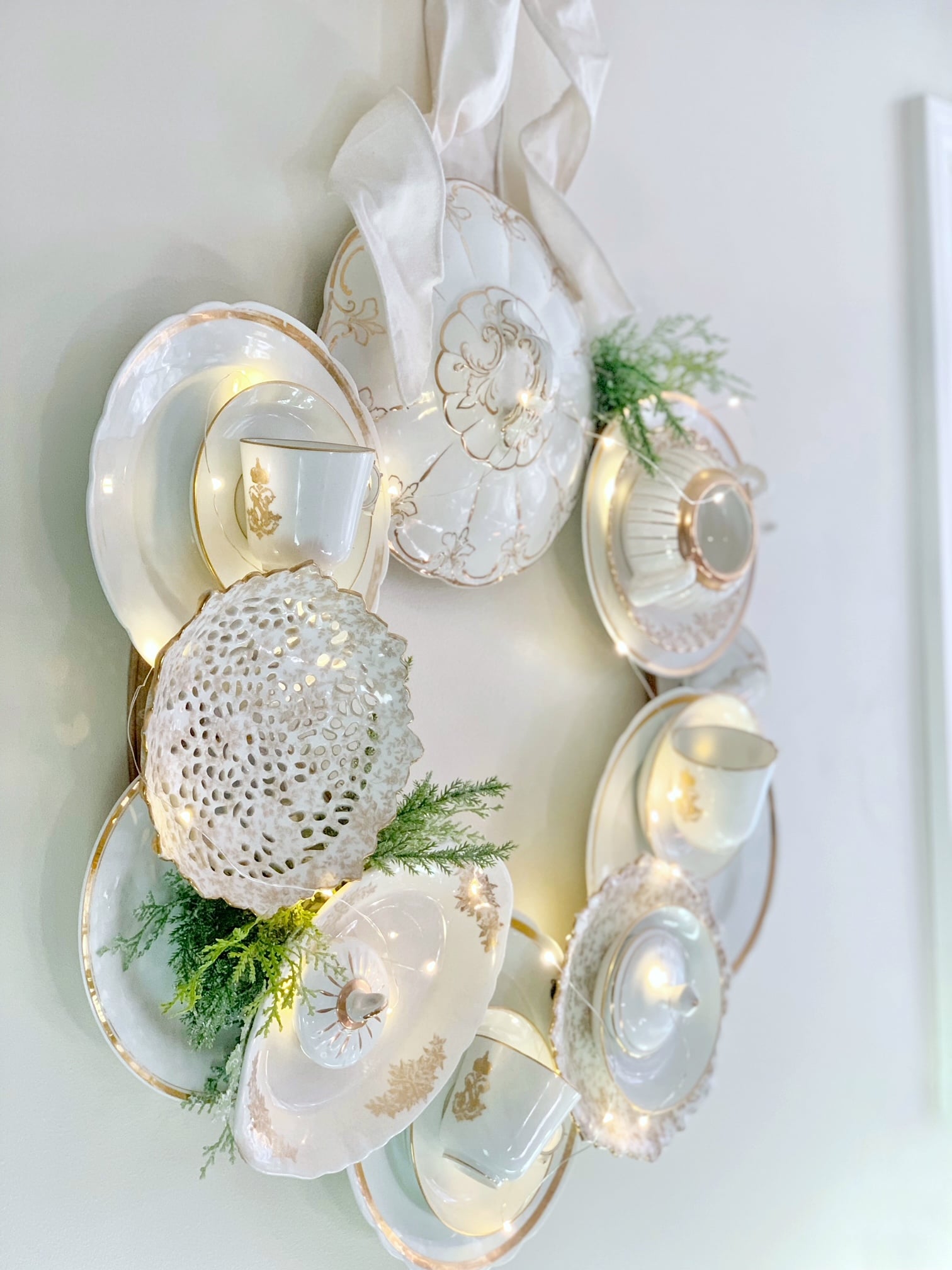 A white Vintage dresser with all white gallery wall with green and white arrangement.