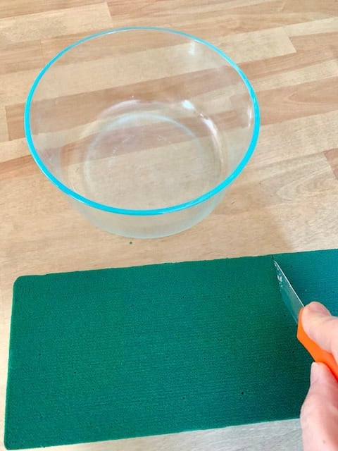 Cutting fresh Floral foam to fit in a container.