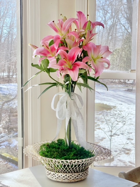finished lily arrangement. the lilies are grouped and tied with ribbon to create a lily topiary. 