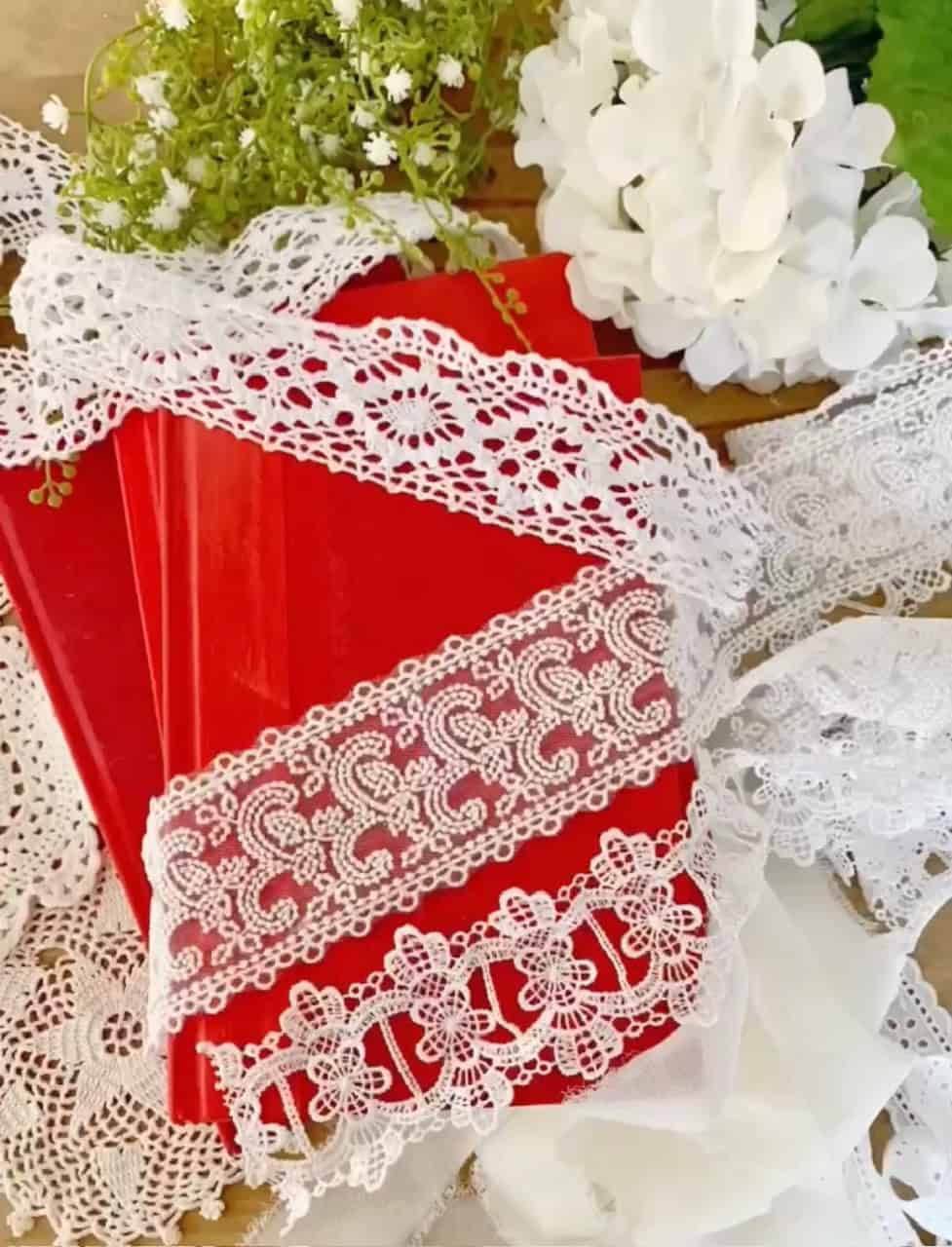 The supplies to make these Valentines Day inspired red book stacks. Ribbon, books and flowers. 