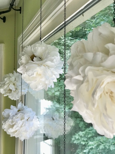 a close up of the peony balls hanging in the window
