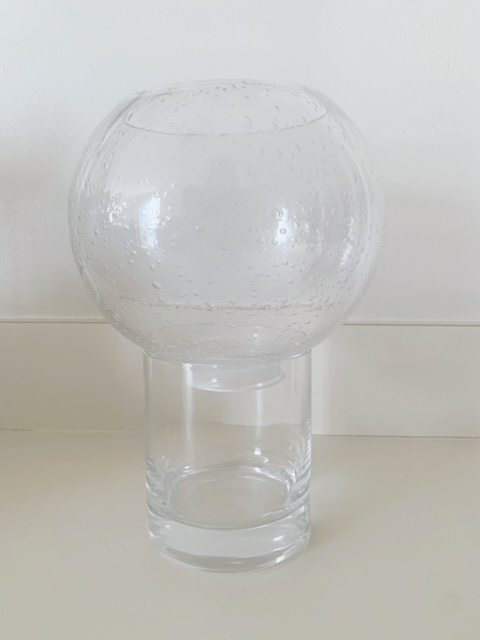 Round globe on cylinder vase, this is a set up for a self watering planter. 