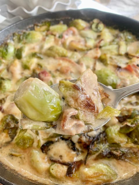 creamy keto brussells sprouts on a fork over the finished recipe