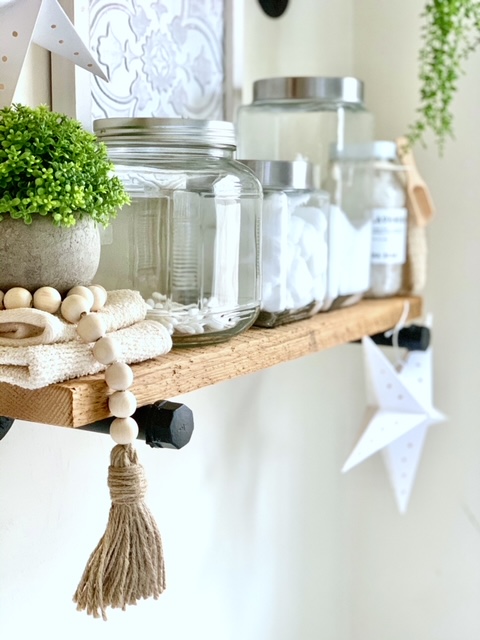 side view of farmhouse shelves with glass canisters and bathroom supplies