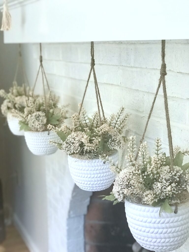 hanging ceramic containers filled with artificial flowers. 