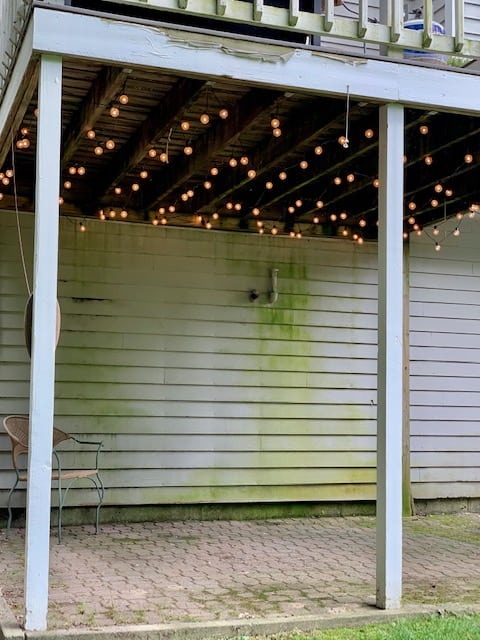 The before picture of the under deck space empty with just cafe lights. 