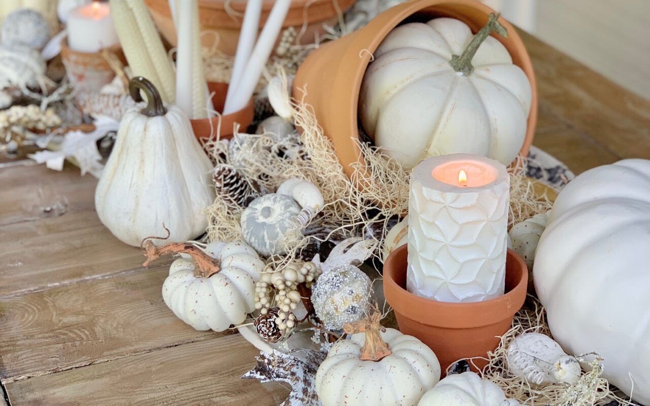 tabel runner with pumpkins, clay posts and candles.