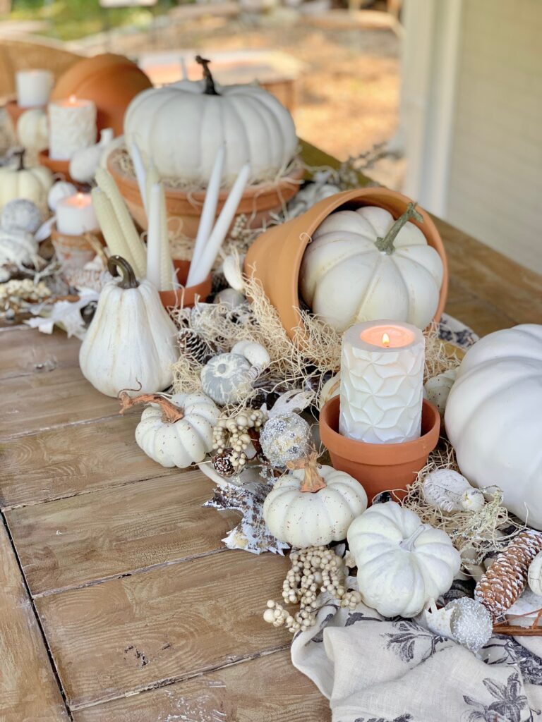 tabel runner with pumpkins, clay posts and candles.