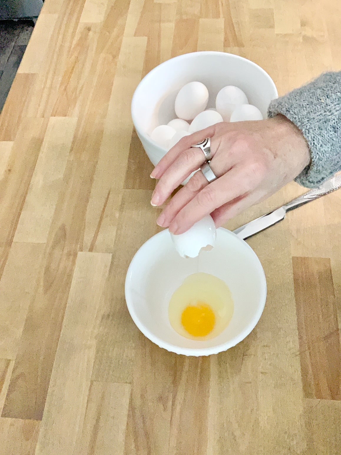 Dumping egg into a bowl.