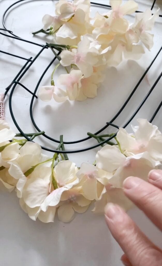 adding the hydrangea to the heart shaped wreath form. 