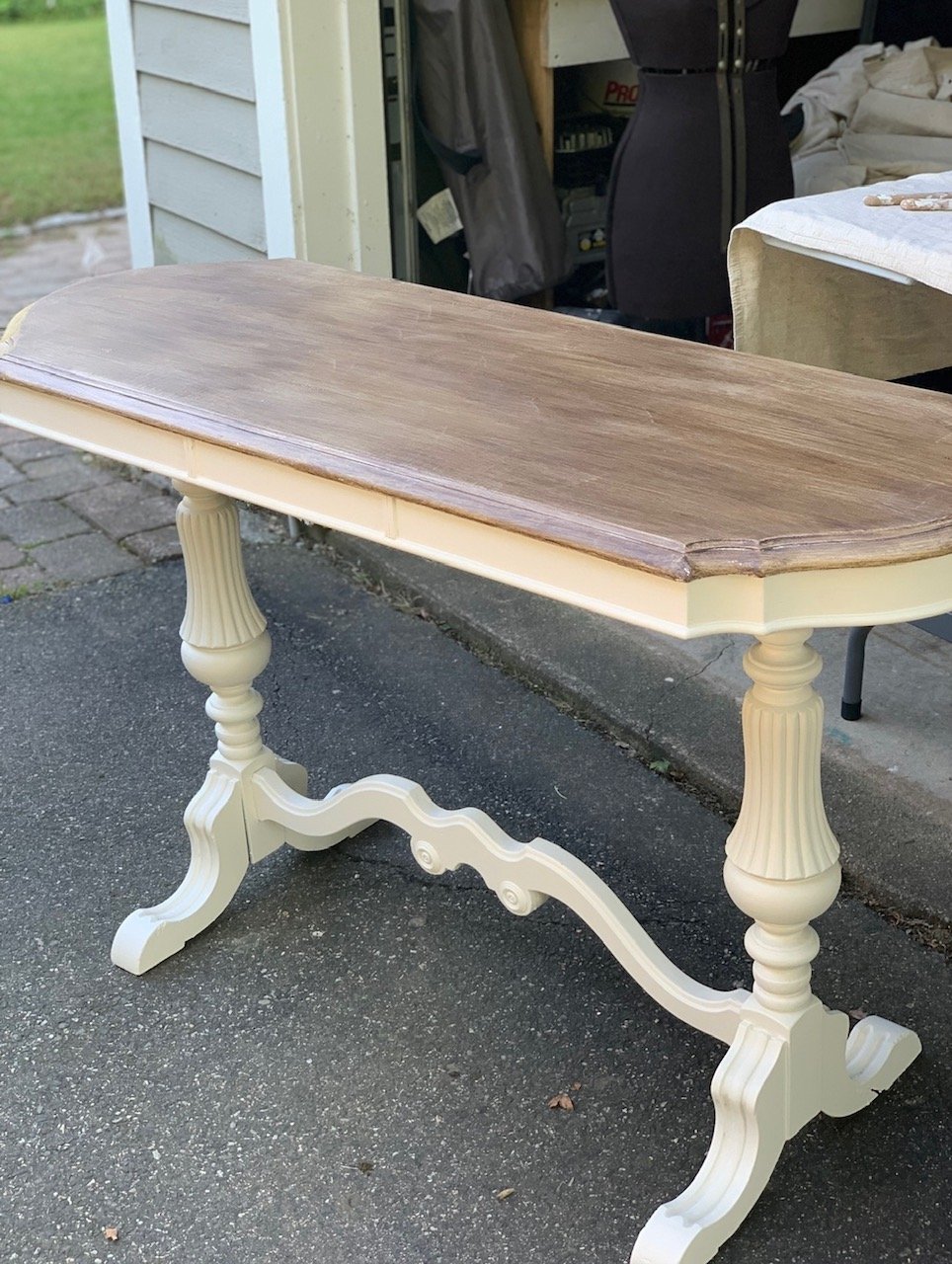 an entry way table or a console table with cream color legs with faux wood table top. 