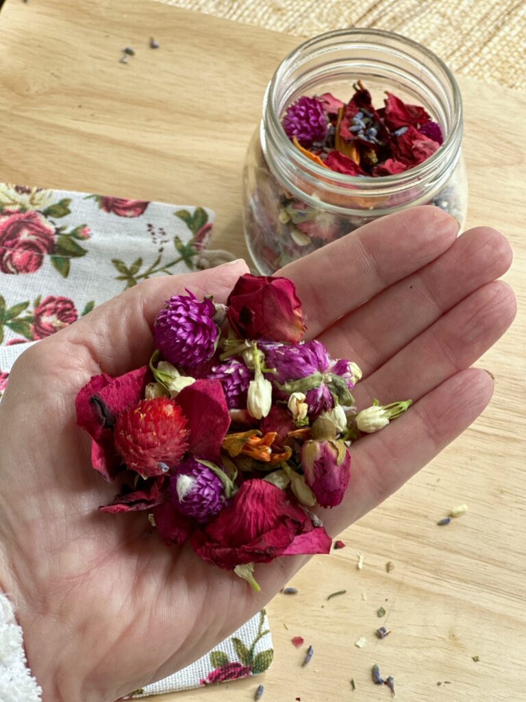 hand holding the dried potpourri with dried rose petals. 