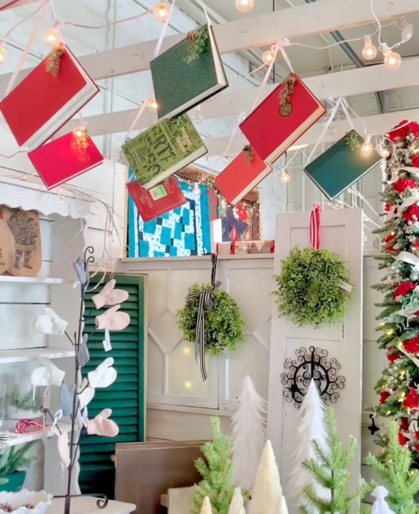 red and green books hung with ribbon from a pergola at my vintage booth. 