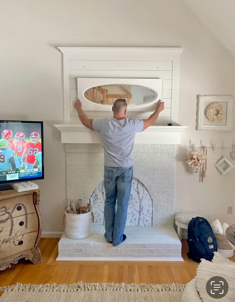 My husband hanging the mirror over the mantel. 