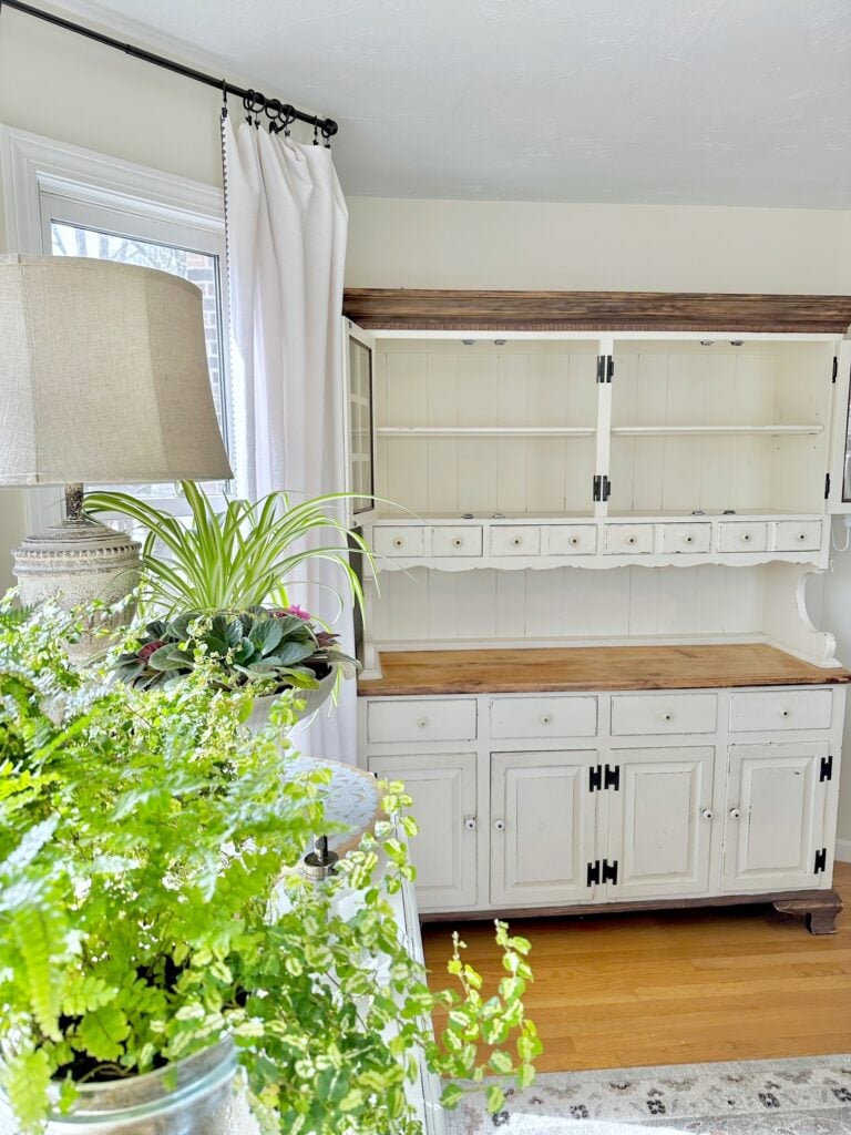 Before photo with the cabinet empty. this is a buffet with hutch style cabinet. The cabinet is painted cream color and the top of the buffet And the top trim is stained wood. 