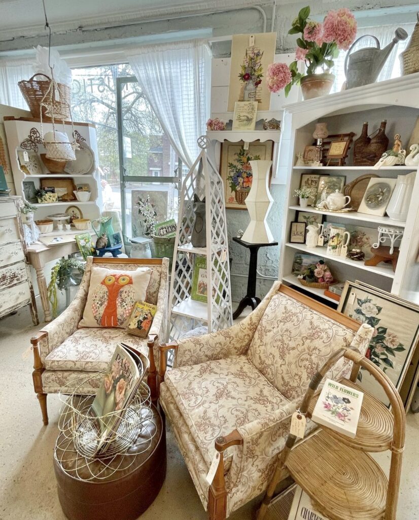 A booth at off the common antiques with chairs, book shelf and lot of fabulous vintage and antique finds. 