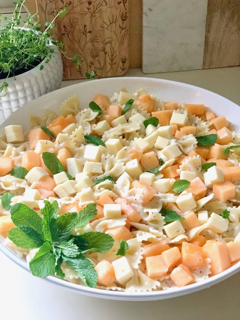 Pasta salad made with bow ties, cantaloupe, cheese and fresh mint. 