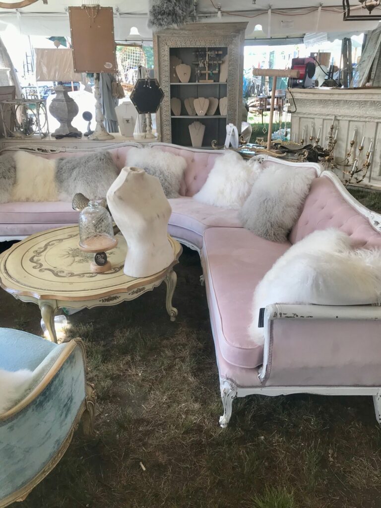 an old antique pink velvet sectional sofa with fluffy pillows. 