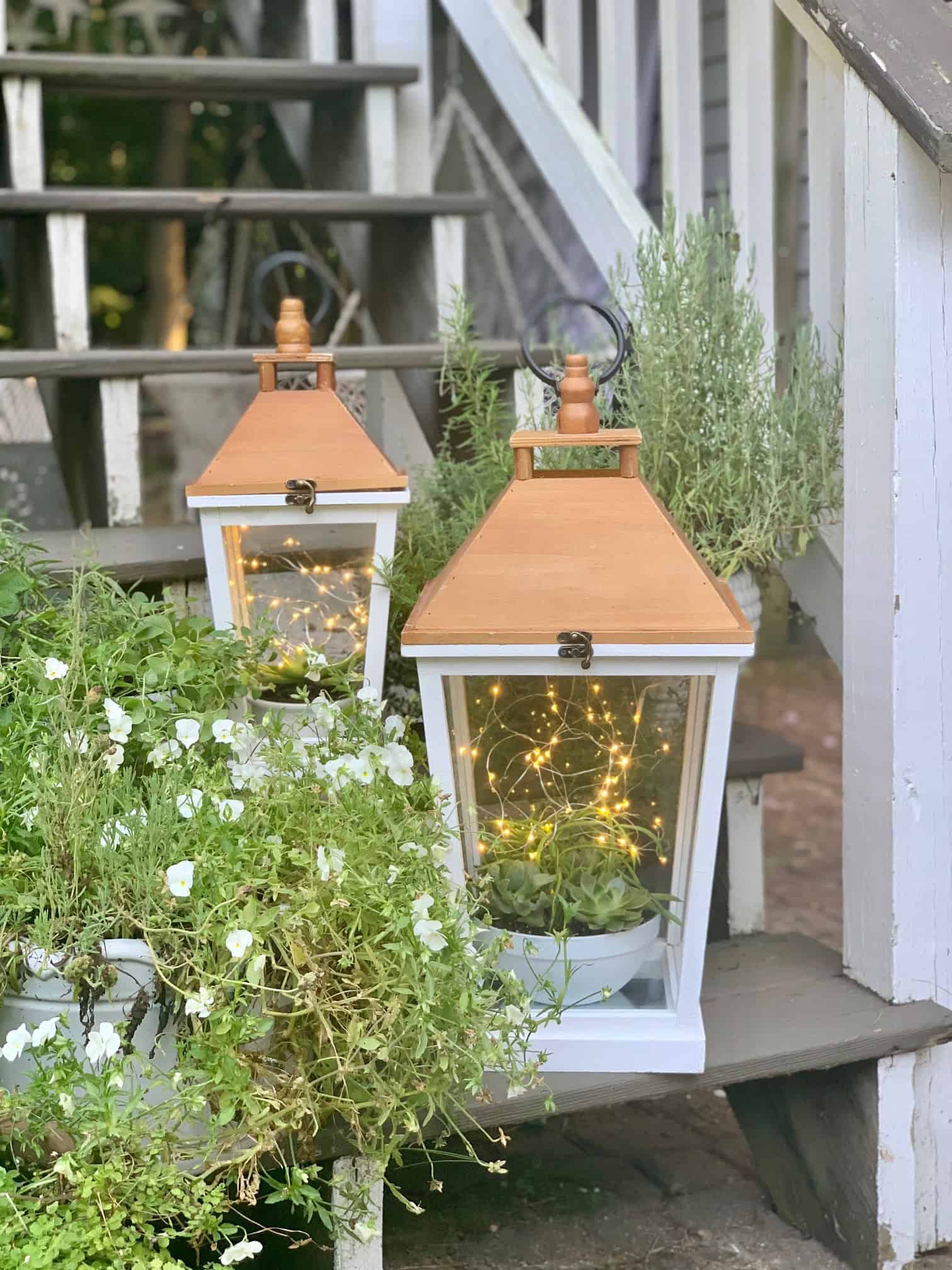 2 Lanterns outside on steps.