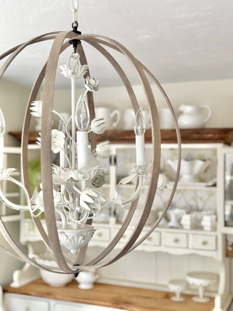 a white metal light fixture that is vintage inspired with embroidery hoops around it in an orb