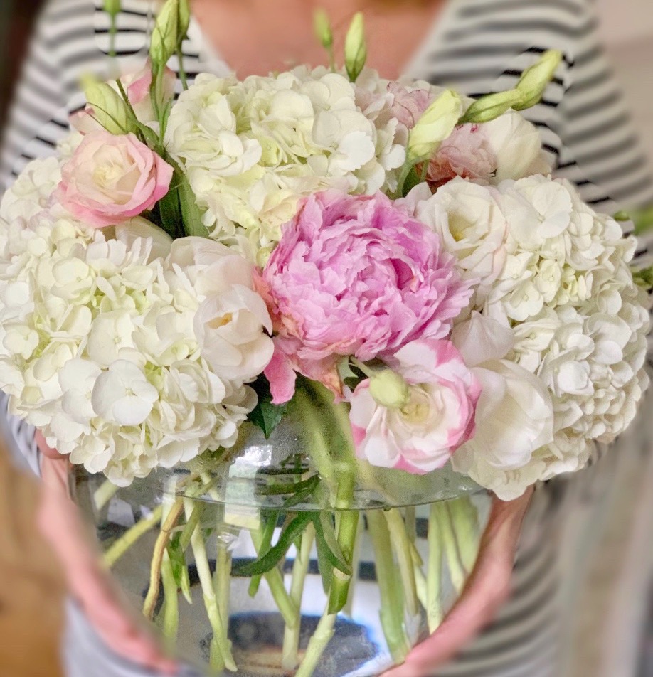 a photo of me holding the bubble ball arrangement with pink peonies.