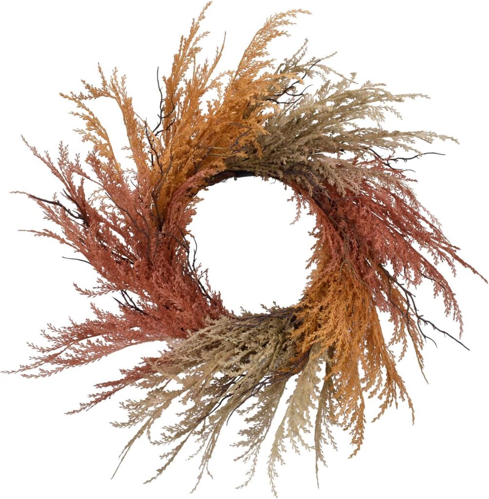 a feathery plume like flower on a twig wreath base. the plumes are beige, reg and orange tone and design in a color block pattern. 