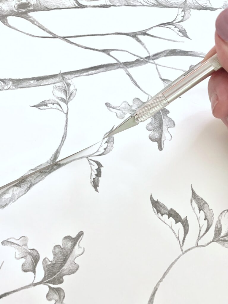 Using an Xacto knife to cut the edges of the paper. 