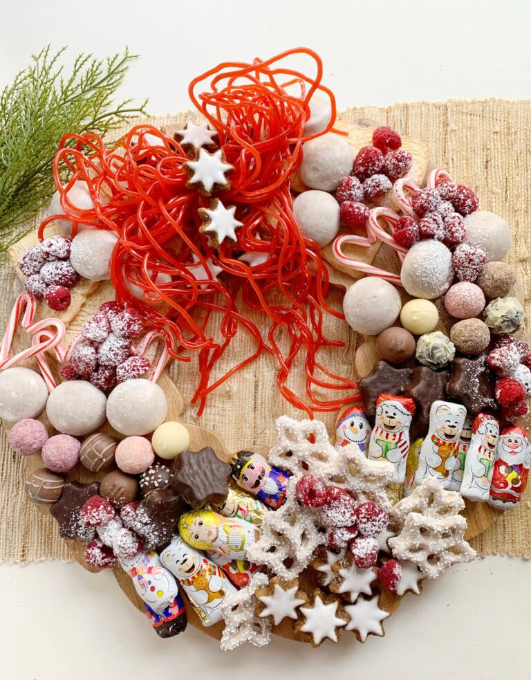 a wreath shaped charcuterie board with candy and cookies.