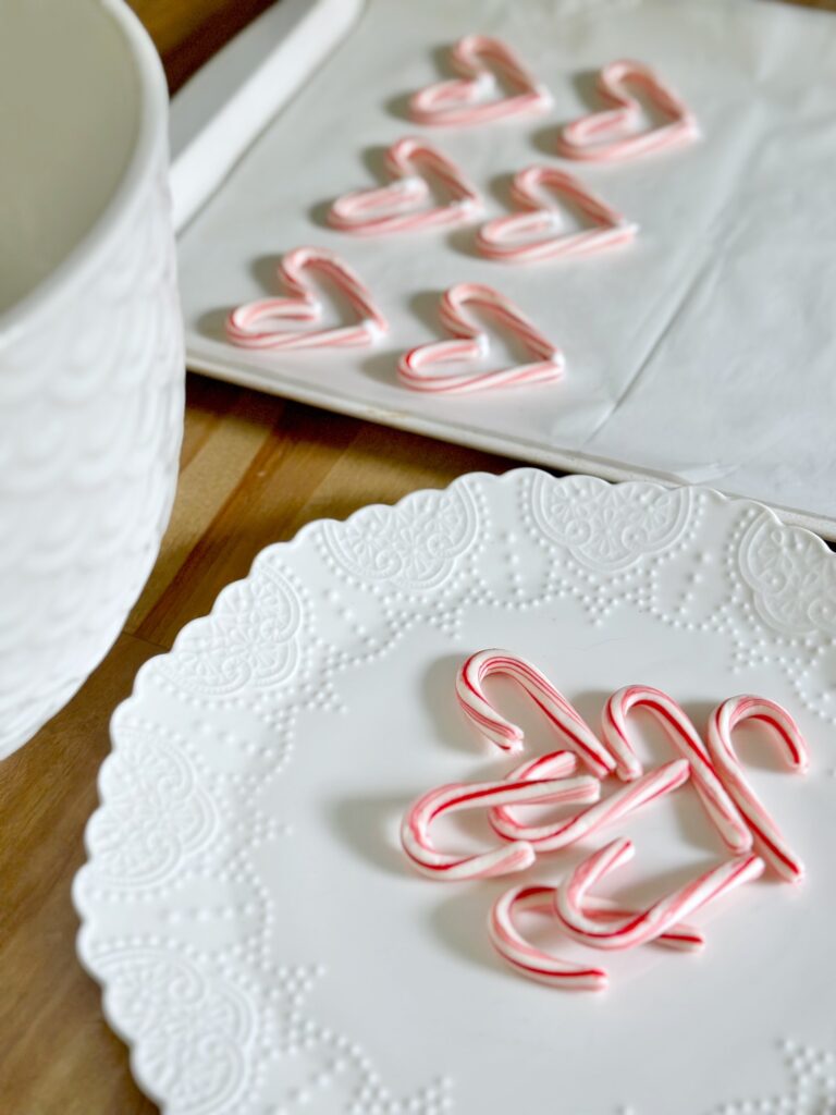  a white plate with mini candy canes, a large bowl of meringue and cookie sheet with heart candy canes. 