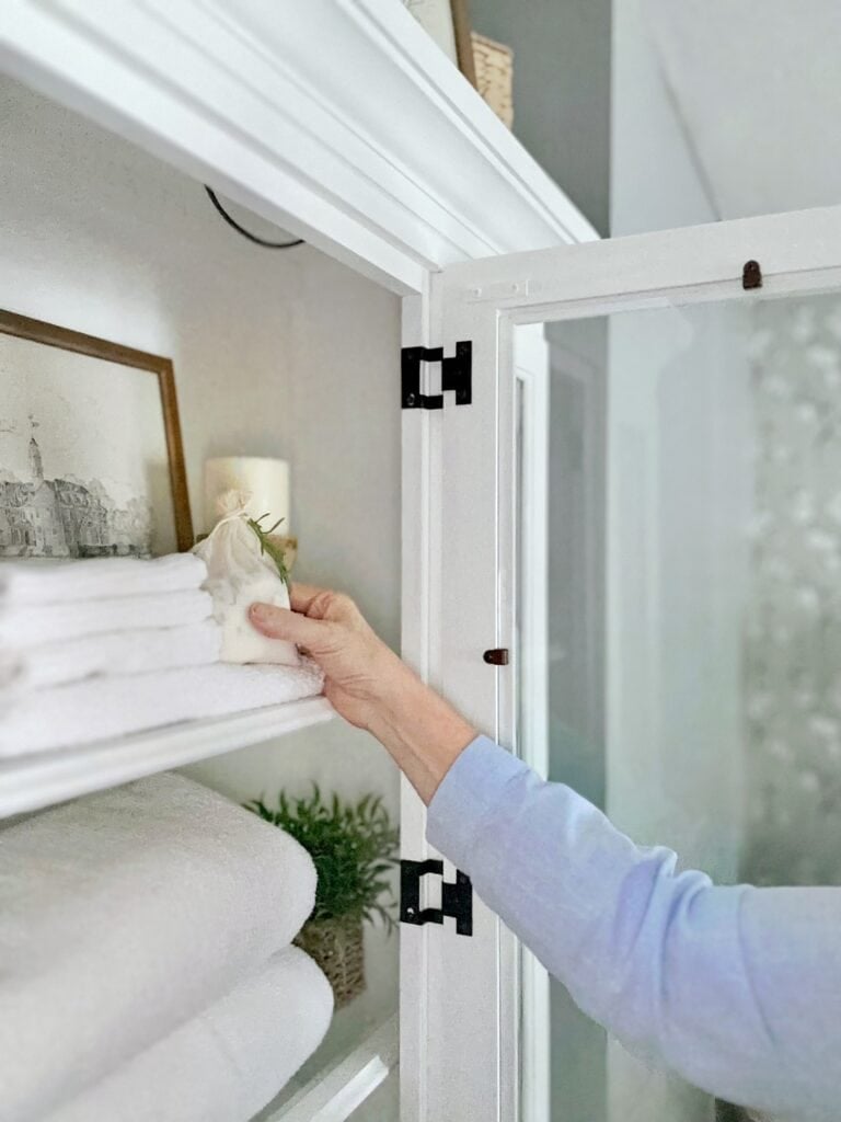 Placing a herb sachet in a linen cabinet. 