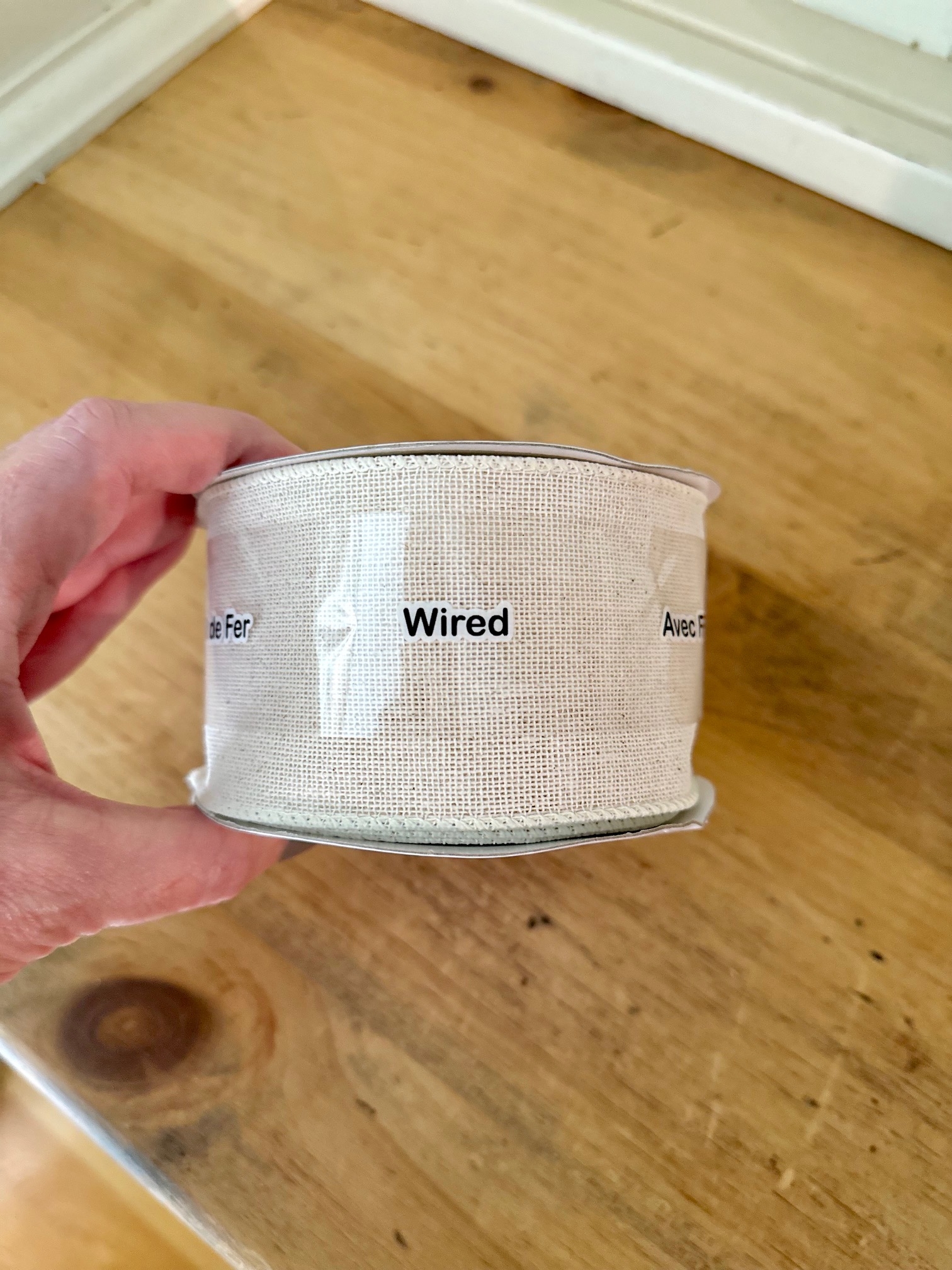 A wide cream colored ribbon ribbon with a wrap that reads "wired".