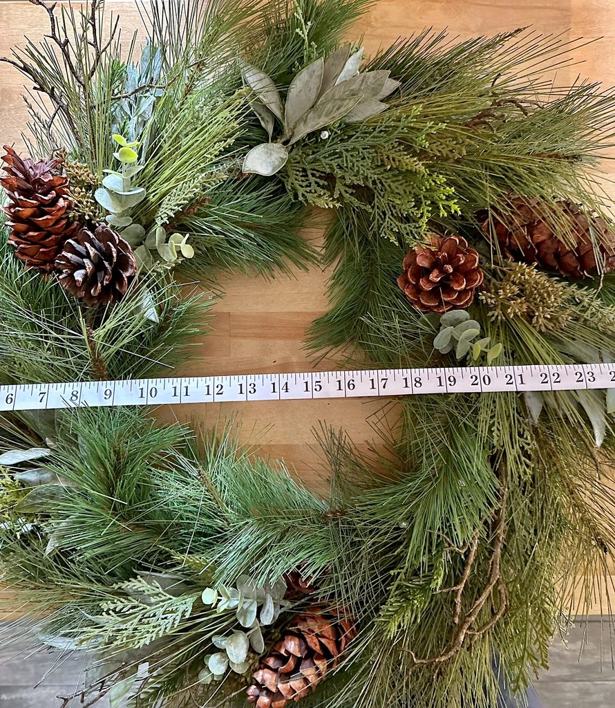 Wreath with a tape measure running across to determine the width of the wreath.