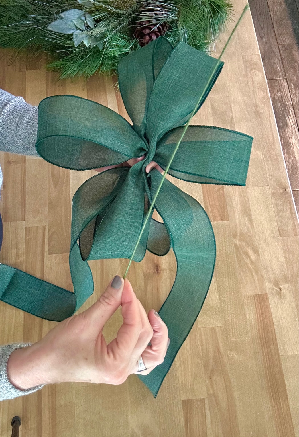 A long piece of flocked wire over a bow that is ready to be "tied" with the wire.
