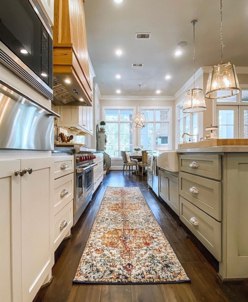 same green and white kitchen showing a colorful rug runner between the island and counter. 