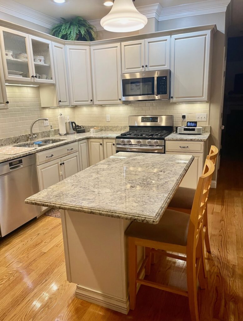 a medium size kitchen island with a granite counter top. 