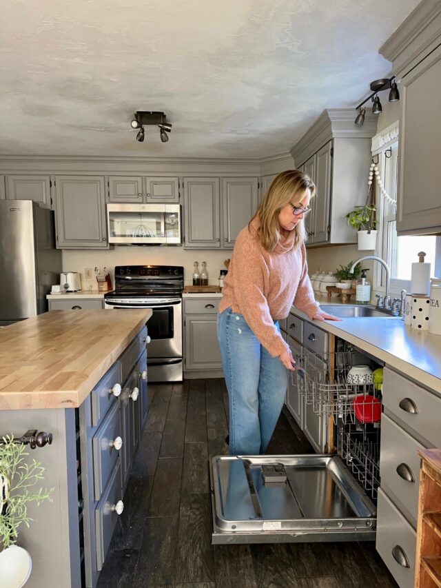 a photo of me opening our dishwasher which sits between our counter and Island.