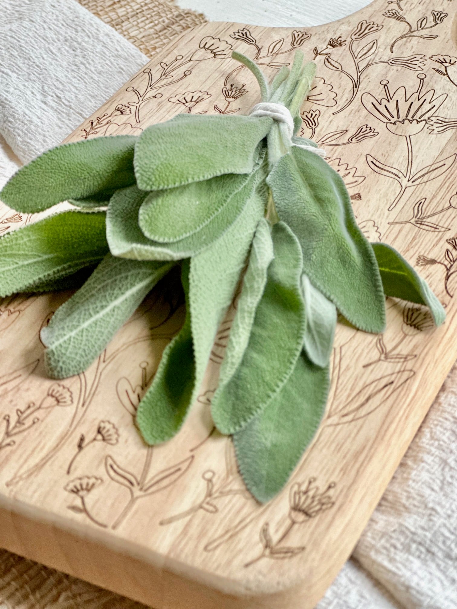 Large bundle of fresh sage on a cutting board.