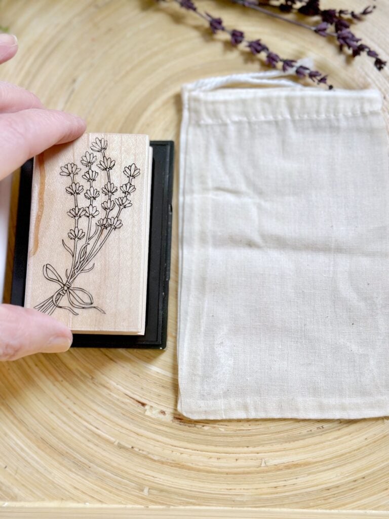 A wooden stamp of lavender, stamp pad and muslin drawstring bag.