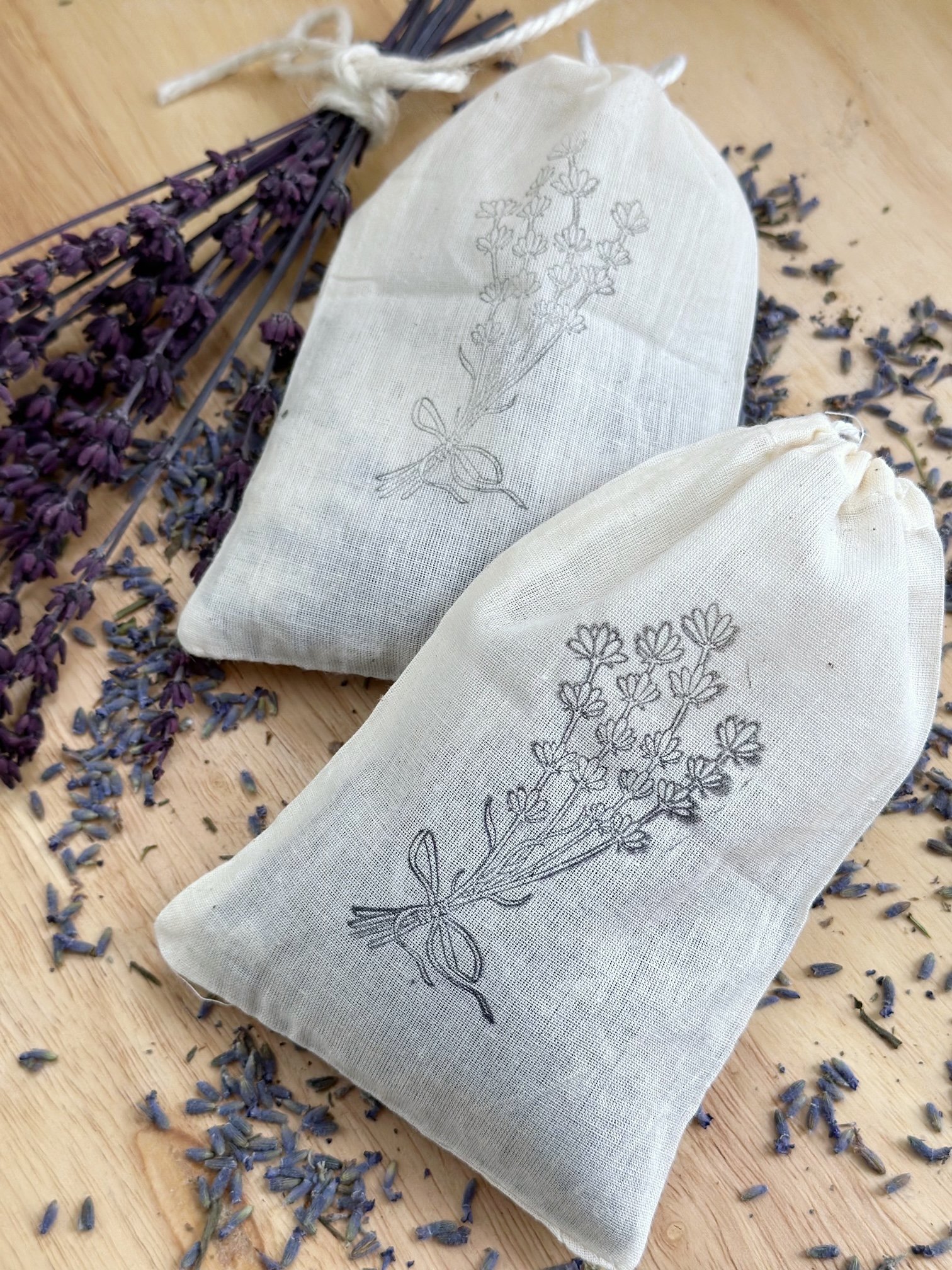Two sachets with lavender sprinkled around them.