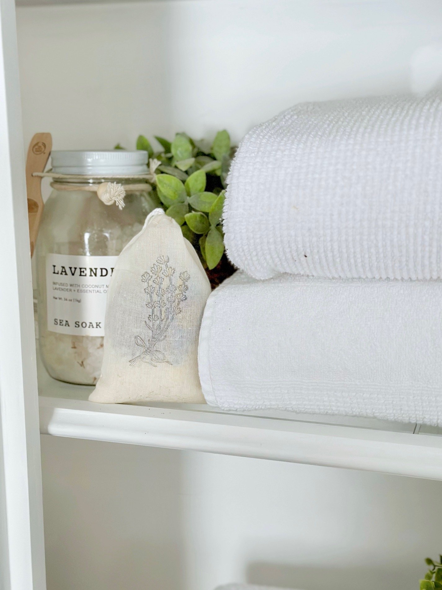 Lavender sachet in linen closet with towels and lavender bath salts.