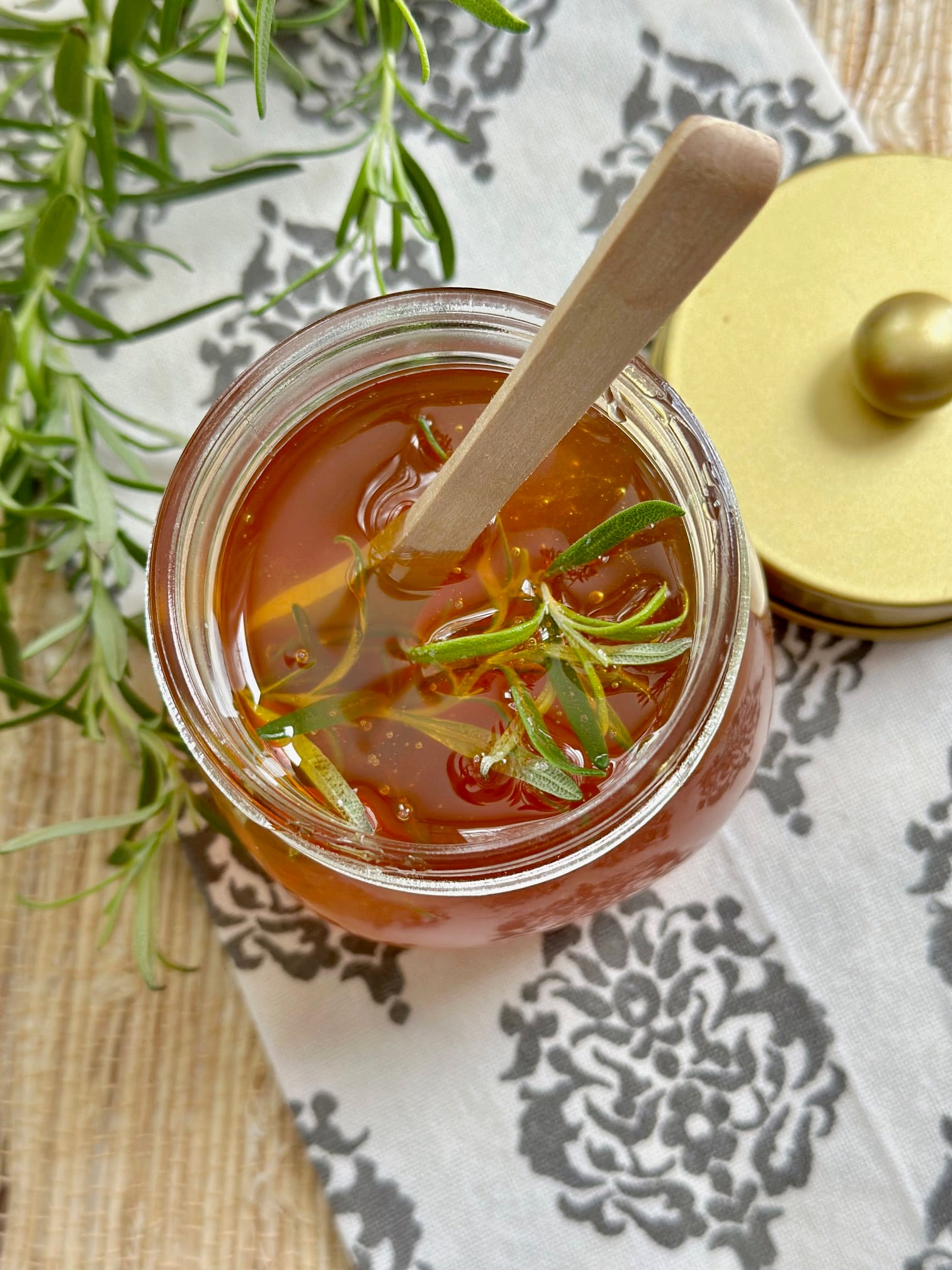 Top view of honey with fresh rosemary in it. 