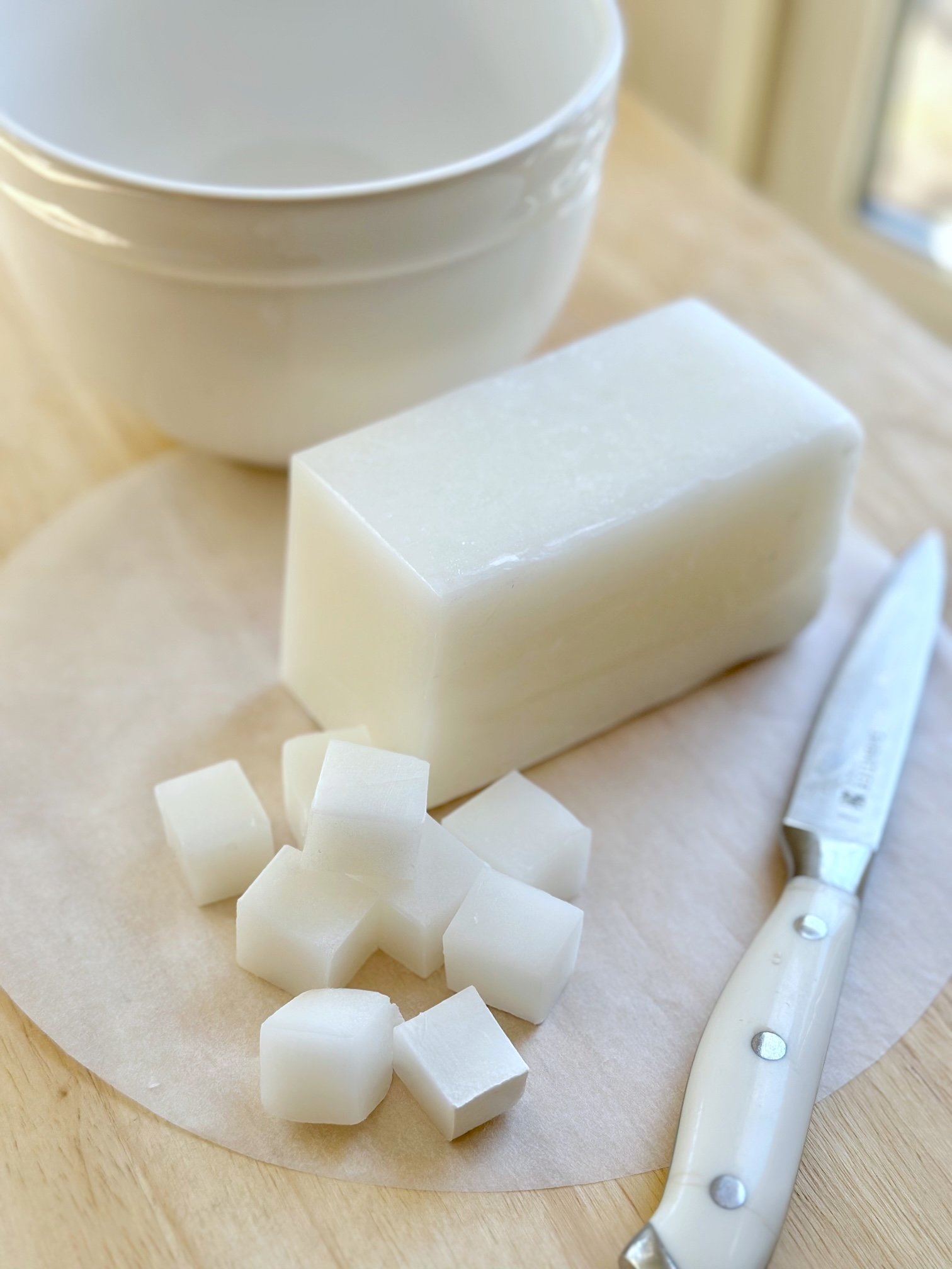 A block of goats milk cut into cubes for melting.